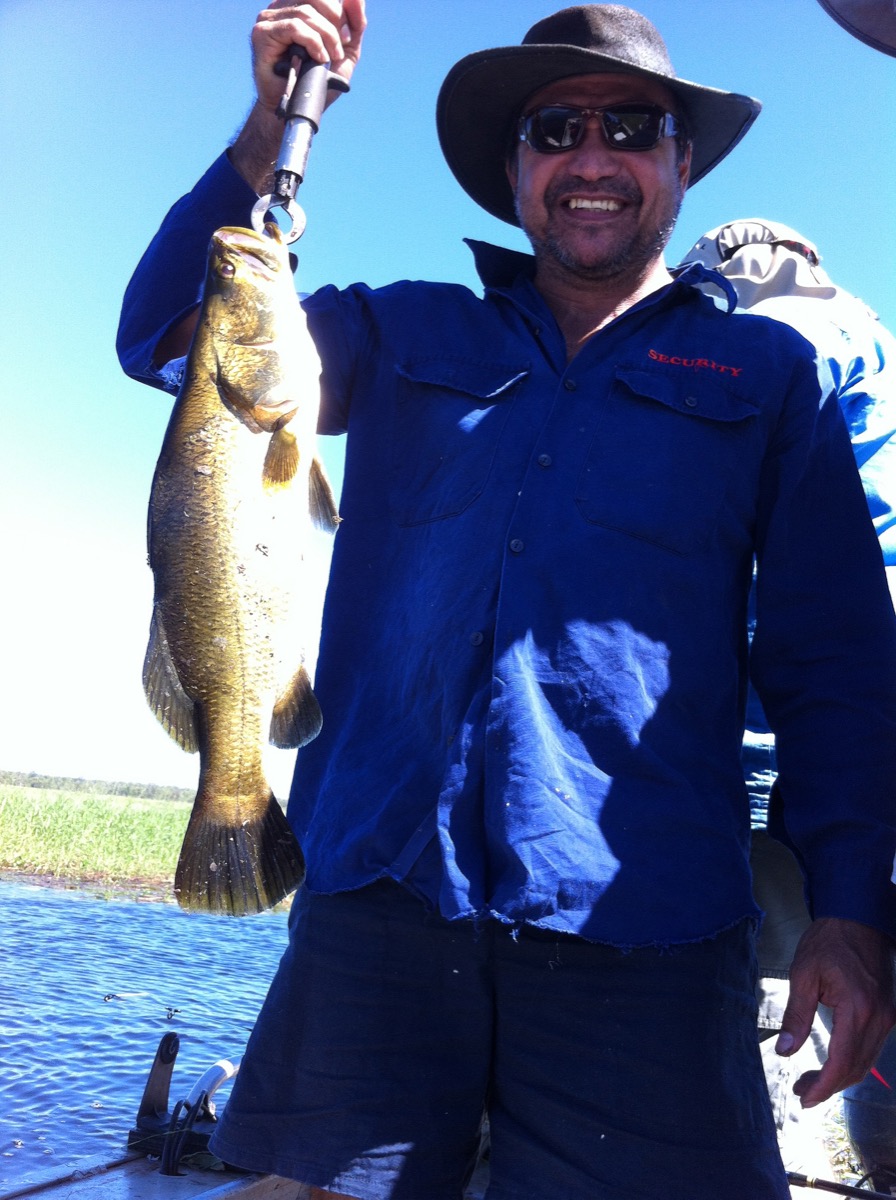 Angler holding a barramundi during a fishing trip in Arnhem Land, Northern Territory