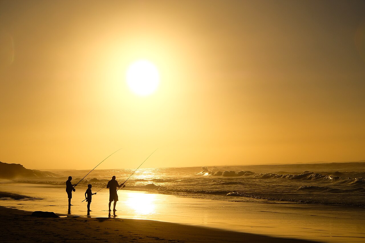 People fishing at sunset on Deadman's Beach in Tasmania