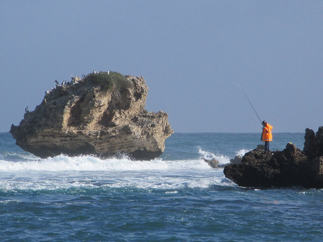 Recreational fisherman standing near Mushroom Rock at Point Peron in Western Australia